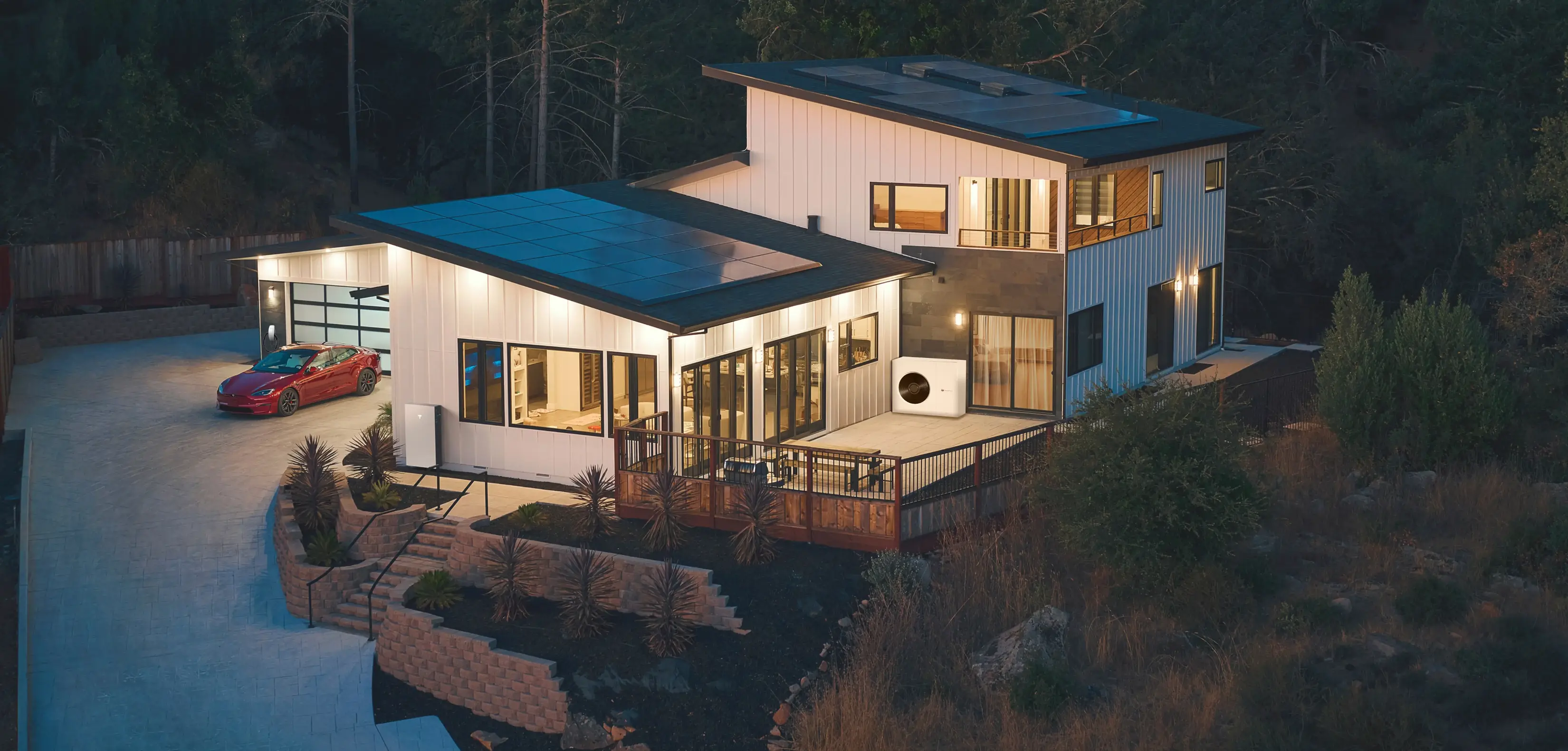 Imagem de uma casa com instalação de painéis solares, bateria, carregador de carro e aerotermia