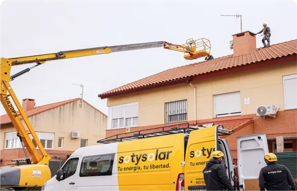 Grua a participar numa instalação de painéis solares junto à carrinha da equipa da empresa SotySolar